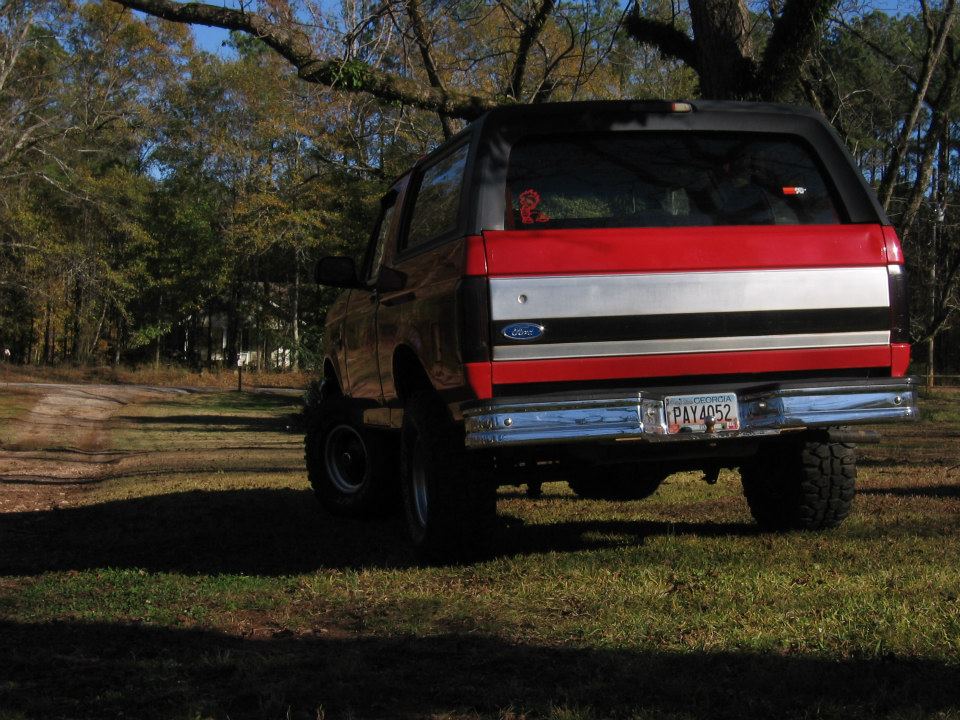 1992 Ford Bronco rear view, lifted, with red, silver, and black stripe on tailgate