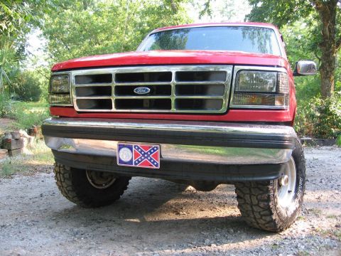 1992 Ford Bronco - Frontal view of a red 1992 Ford Bronco with a chrome grille and bumper.
