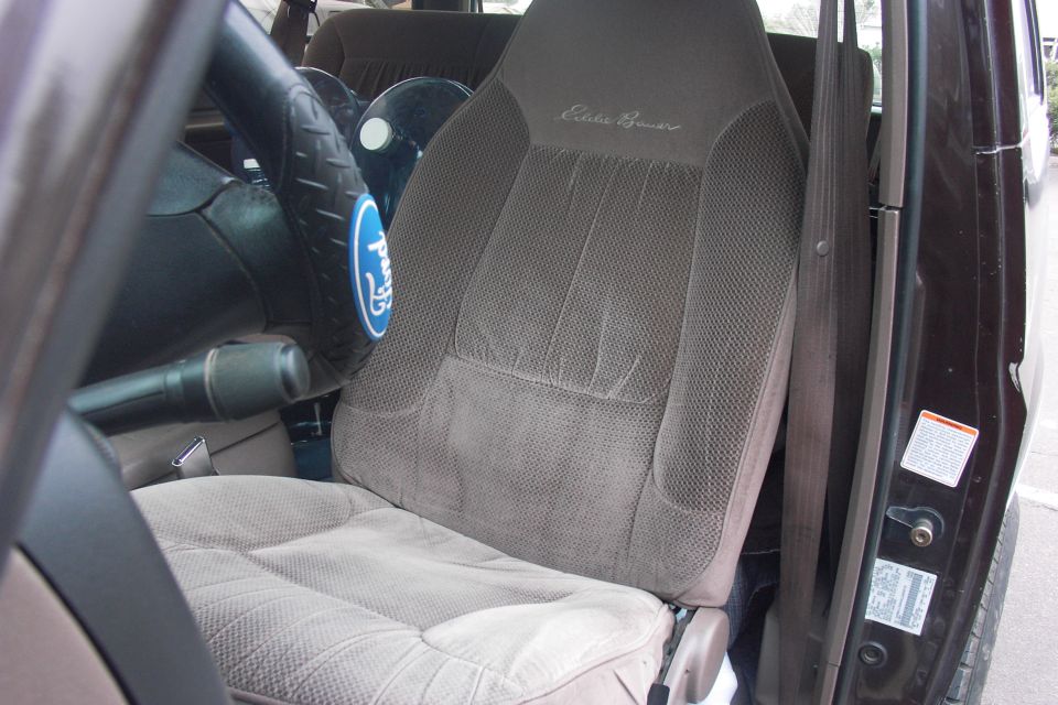 Gray Eddie Bauer cloth driver seat and steering wheel in a 1990s Ford truck
