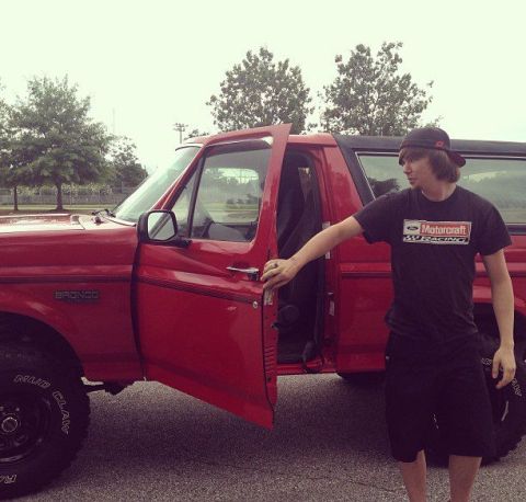 1992 Ford Bronco - Person stands by the open door of a red 1992 Ford Bronco.