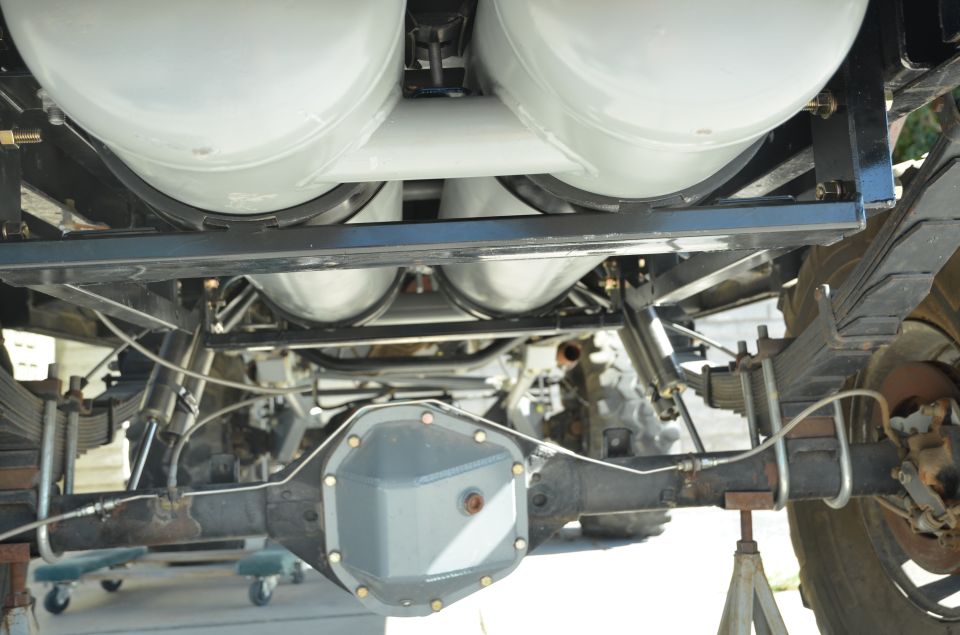 Undercarriage view of propane tanks mounted above rear axle