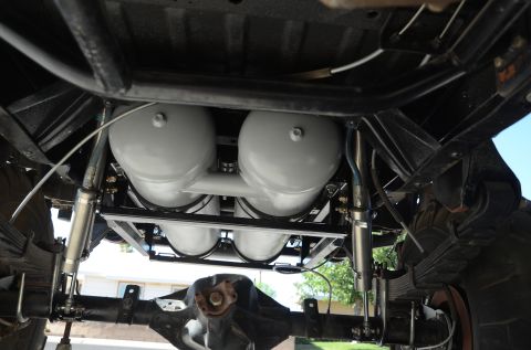 1979 Ford Bronco - Undercarriage view shows four large air tanks installed on the vehicle's frame, with visible suspension components.
