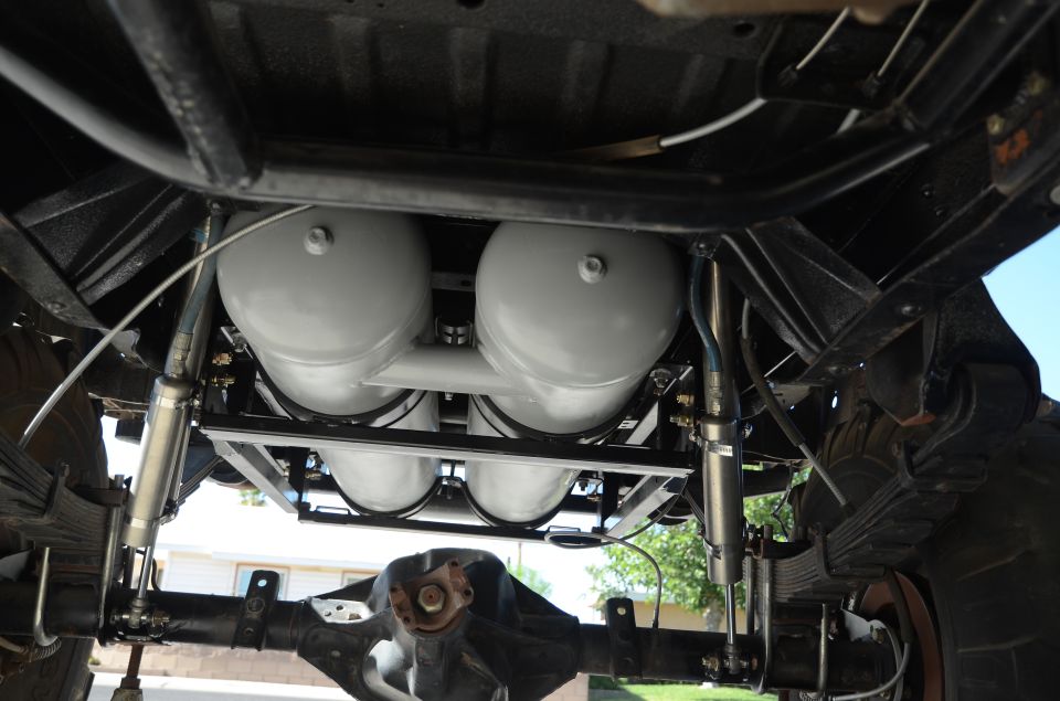 Undercarriage view of four air tanks mounted on a vehicle frame