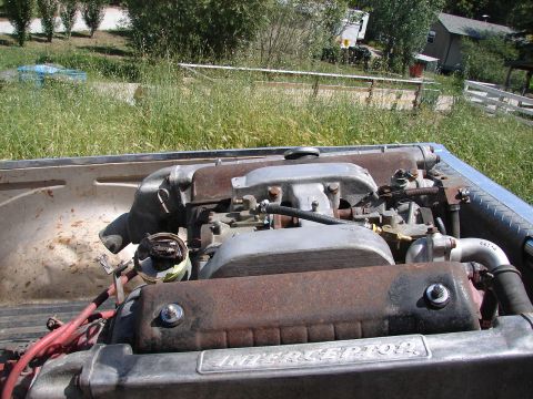 1973 Ford Ranchero - The engine, labeled 'INTERCEPTOR', is partially covered in rust and sits in the bed of a vehicle.
