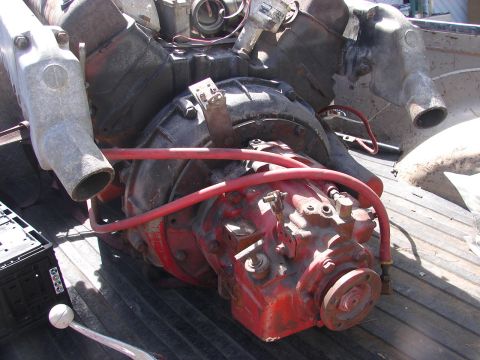 1973 Ford Ranchero - Close-up view of assorted engine and transmission parts, including red-painted components and metal piping, loaded in a truck bed.
