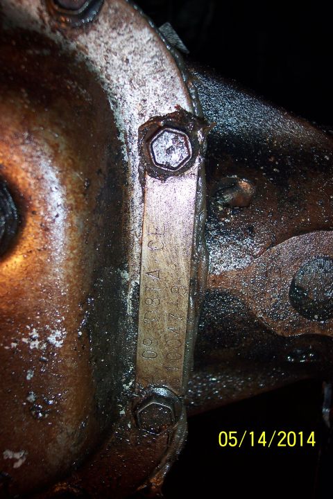 1978 Ford Bronco - A metal tag on a greasy differential housing shows stamped identification numbers and letters.