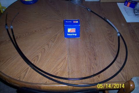 1978 Ford Bronco - Throttle cables and a bearing box are laid out on a wooden surface.