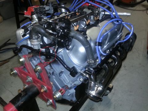 1994 Ford Bronco - Engine assembly with various hoses and components visible, mounted on a stand.