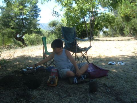 1988 Ford Bronco - A boy plays with toy cars in a wooded area with camping chairs nearby.