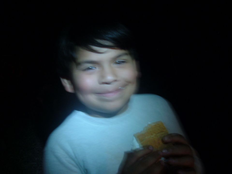 Boy eating a s'more at night