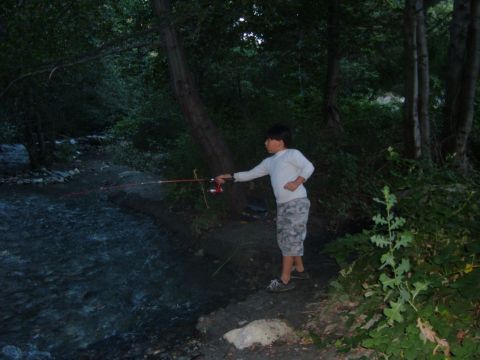 1988 Ford Bronco - A young boy casts his fishing line into a stream surrounded by trees, with the Supermotors logo in the corner.