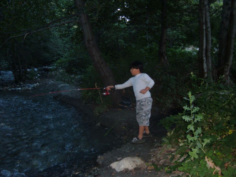 Boy fishing by a stream with Supermotors logo visible
