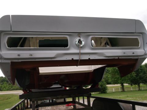 1967 Ford Mustang - The rear section of a car, prepped for restoration, is shown mounted on a trailer outdoors.