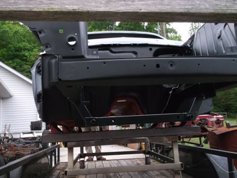 1967 Ford Mustang - The underside of a car's frame is visible, elevated on a trailer for maintenance.