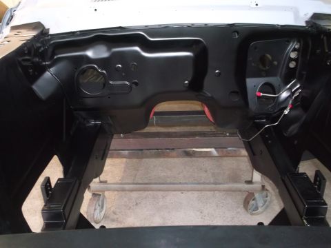 1967 Ford Mustang - The engine bay of a car is shown, mounted on a stand for repair or restoration.