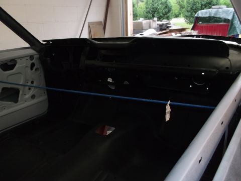 1967 Ford Mustang - Interior view of a 1967 Ford Mustang undergoing restoration, showing the dashboard and partially stripped door panel.