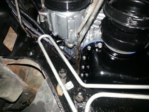1994 Ford Bronco - Close-up view of engine components, including hoses and metal brackets, with visible signs of wear and new parts.