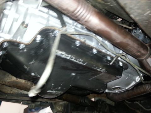 1994 Ford Bronco - Close-up view of the underside of a vehicle, focusing on the transmission and exhaust components.