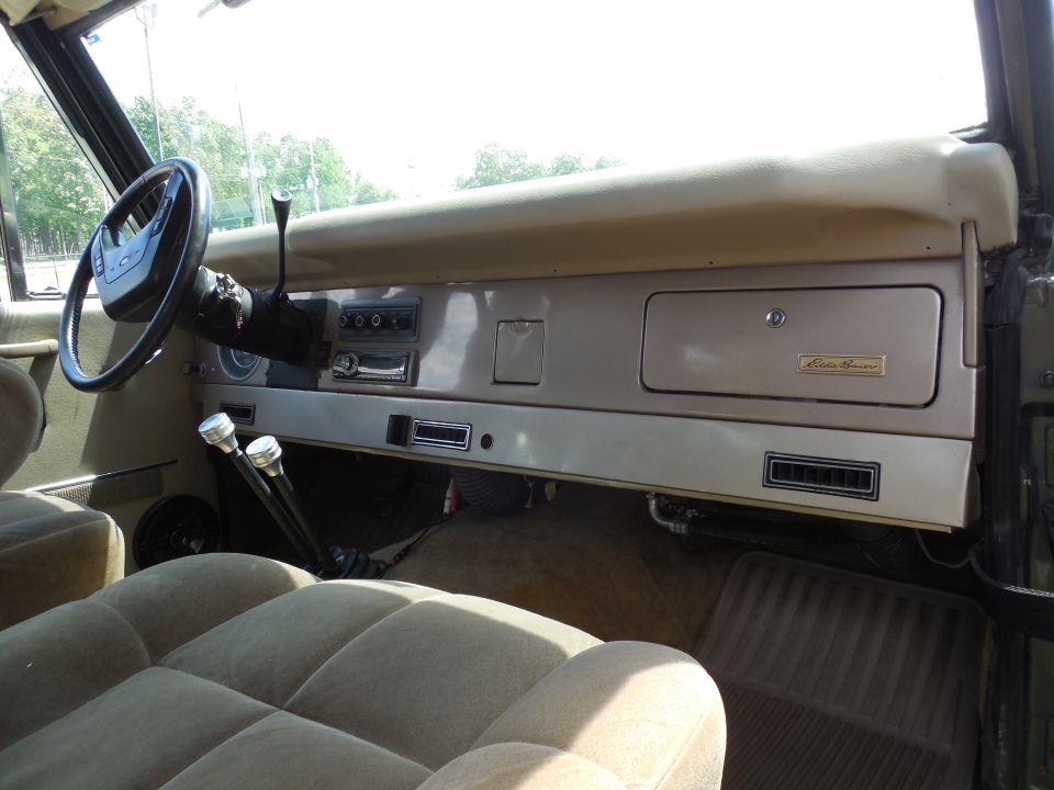 Tan Ford Bronco interior with Eddie Bauer glovebox badge, twin floor shifters and cloth seats