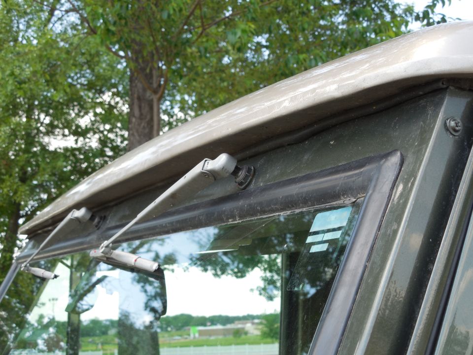 Windshield wipers on a tan and dark green vehicle
