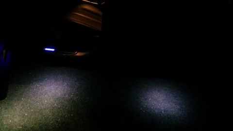 2014 Subaru Outback - The interior of a car is dimly lit, showing illuminated door sills and puddle lights.