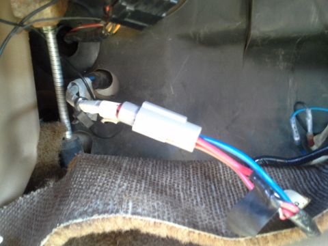 1991 Ford F-250 - Close-up view of a wiring harness connector and associated wires located beneath the dashboard of a vehicle.