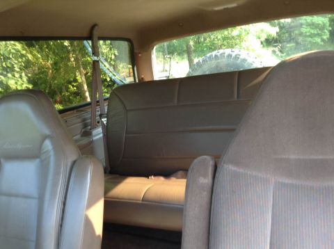 1995 Ford Bronco - Interior view of an SUV showing the rear bench seat and a spare tire mounted externally.