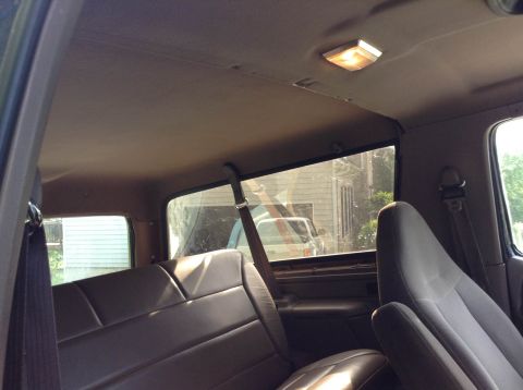 1995 Ford Bronco - Interior view of a vehicle's rear seats and headliner, with another vehicle visible through the window.