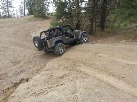 2005 Jeep Wrangler - A Jeep Wrangler navigates a steep, sandy incline on an off-road trail.