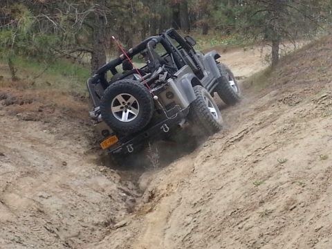 2005 Jeep Wrangler - A Jeep Wrangler navigates a steep, dusty incline on an off-road trail.