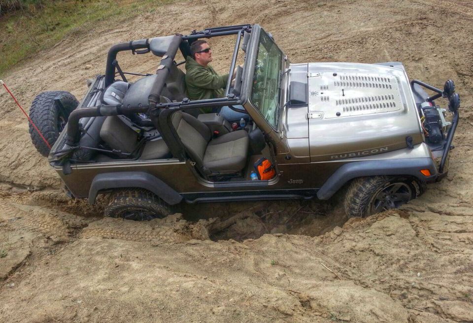 2005 Jeep Wrangler Rubicon stuck in a dirt pit with driver inside