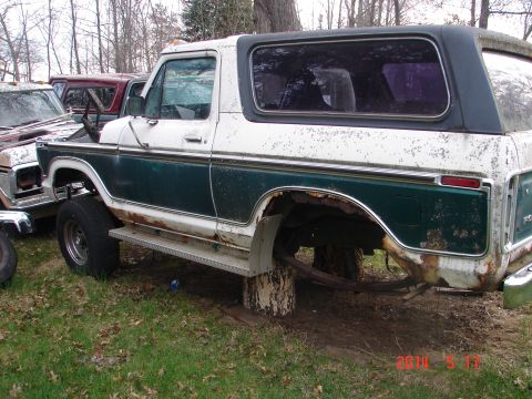 1978 Ford Bronco - Side view of a 1978 Ford Bronco, showing its two-tone paint and some rust.