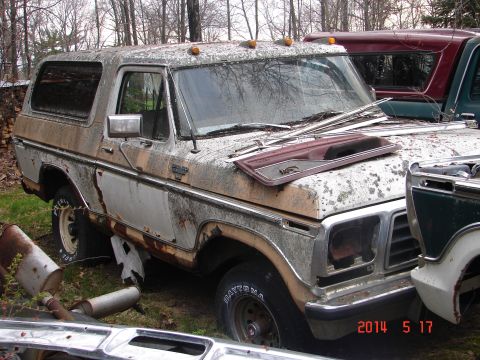 1978 Ford Bronco - This weathered Ford Bronco sits in a yard, showing signs of age and neglect.