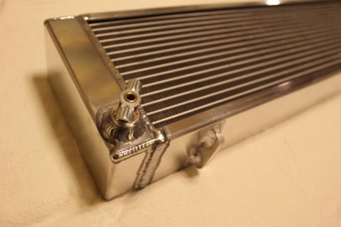 2003 Ford Crown Victoria - Macro close-up of a polished aluminum heat exchanger corner showing fin core, weld beads and a small brass fitting.