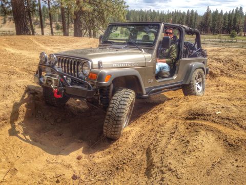 2005 Jeep Wrangler - A Jeep Wrangler Rubicon navigates a sandy, off-road trail with a driver behind the wheel.
