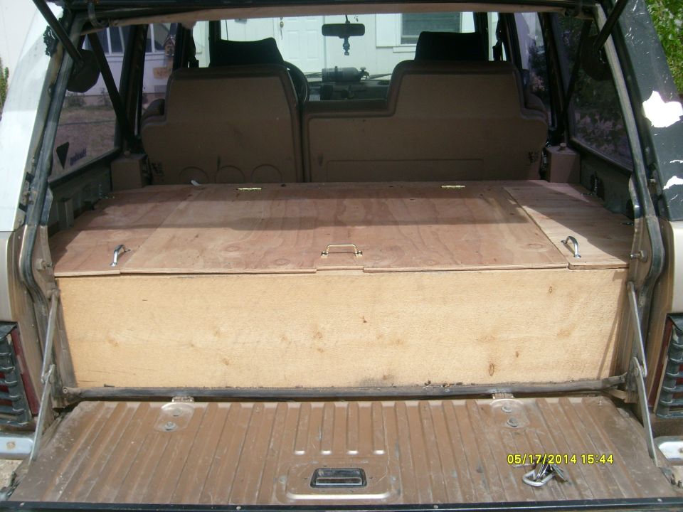 Interior cargo area of a vehicle with a custom wooden storage box installed