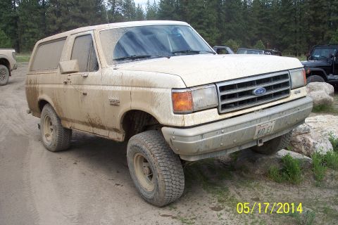 1990 Ford Bronco - This off-road vehicle is covered in mud, suggesting it has been used for off-roading.