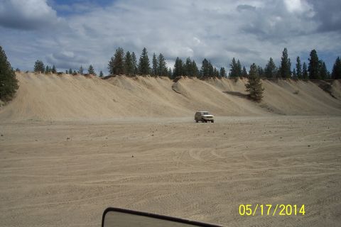 1990 Ford Bronco - A 1990 Ford Bronco is seen in a vast sandy terrain under a cloudy sky.