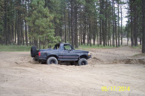 1990 Ford Bronco - This 1990 Ford Bronco is navigating a sandy trail surrounded by pine trees.