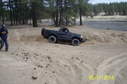 1990 Ford Bronco - 1990 Ford Bronco navigating a sandy terrain off-road.