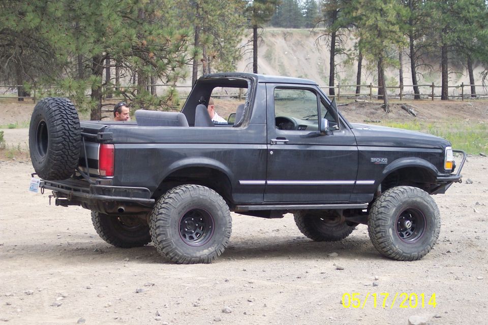 Black 1990 Ford Bronco with spare tire on rear, lifted suspension, and off-road tires