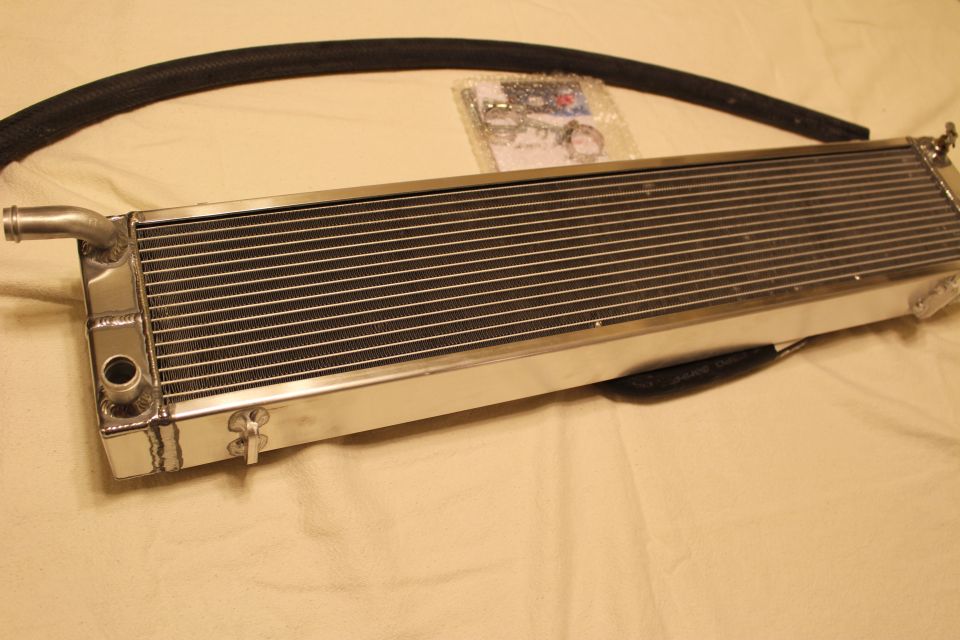 Polished aluminum heat exchanger with end barb, curved black hose and hardware bag