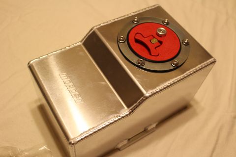 2003 Ford Crown Victoria - fabricated aluminum fuel cell rests on cloth, its red billet flip-up cap visible and a Moroso logo embossed on the side.