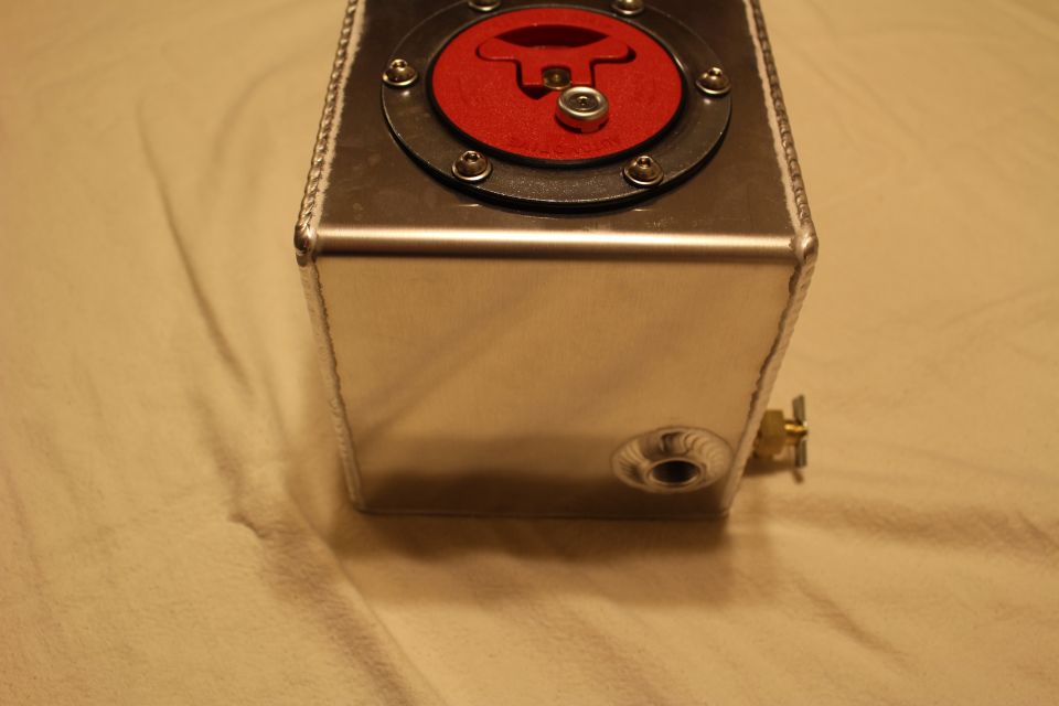 End view of aluminum fuel cell with red cap and brass fitting in side bung