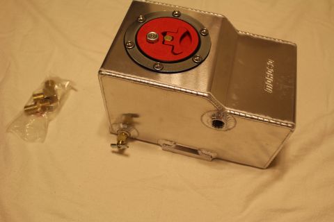 2003 Ford Crown Victoria - welded aluminum fuel cell with a red flip-up filler cap, threaded side bungs and a bag of brass fittings nearby.