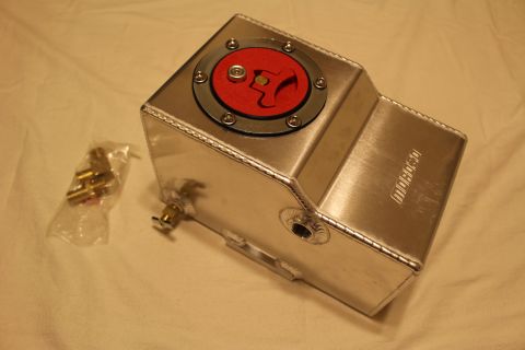 2003 Ford Crown Victoria - fabricated aluminum fuel cell with red billet cap and a brass petcock fitting installed, shown beside bagged brass parts.