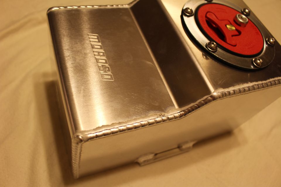 Close aluminum fuel cell showing welded seams and embossed Moroso logo