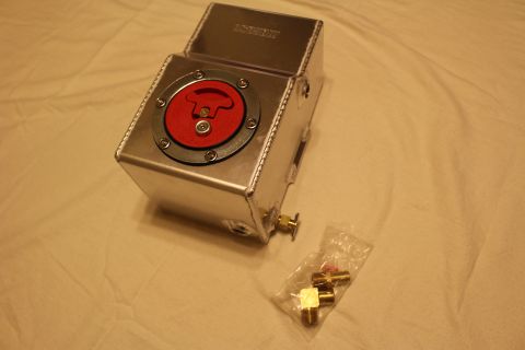 2003 Ford Crown Victoria - taller welded aluminum fuel cell stands with its red flip-up filler cap facing forward and a bag of brass fittings beside it.