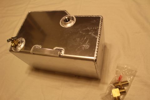 2003 Ford Crown Victoria - Rear view of a polished aluminum fuel cell with a flush recessed handle and welded bungs, next to bagged brass fittings.