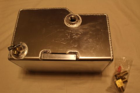 2003 Ford Crown Victoria - Rear view of a welded aluminum fuel cell showing a recessed handle, brass corner fitting and welded bungs with bagged spares.